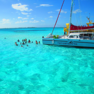 tourists standing in the shallow waters of the crystal blue Caribbean Sea