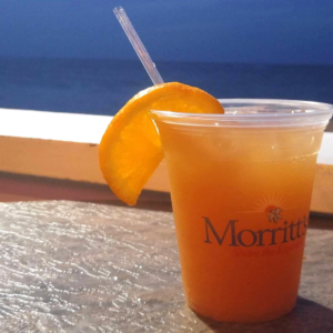 Bright orange cocktail garnished with a slice of orance