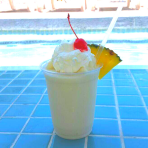 A frozen Piña Colada garnished with a pineapple slice and a cherry