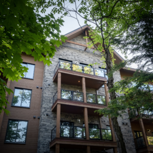 peering at a timber and stone lodge through some trees 