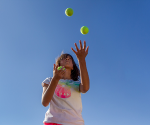 child learning how to juggle