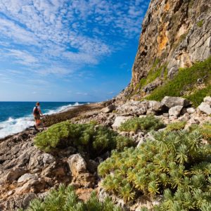 A hiker walking alongside the bluff by the Caribbean Sea